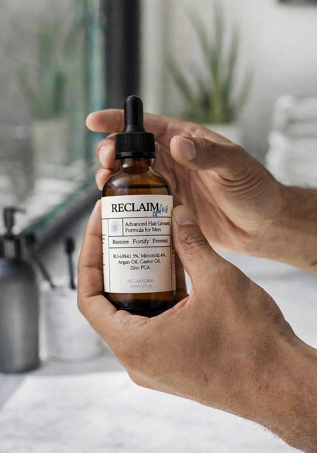 Hand holding the Reclaim Gang RU58841 and minoxidil serum